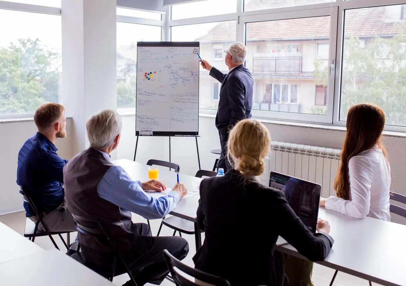 A senior businessman delivering a presentation to colleagues in the office.